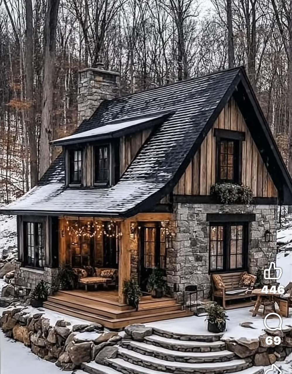 Cozy stone and wood cottage with snow-dusted roof and string lights on porch in winter forest