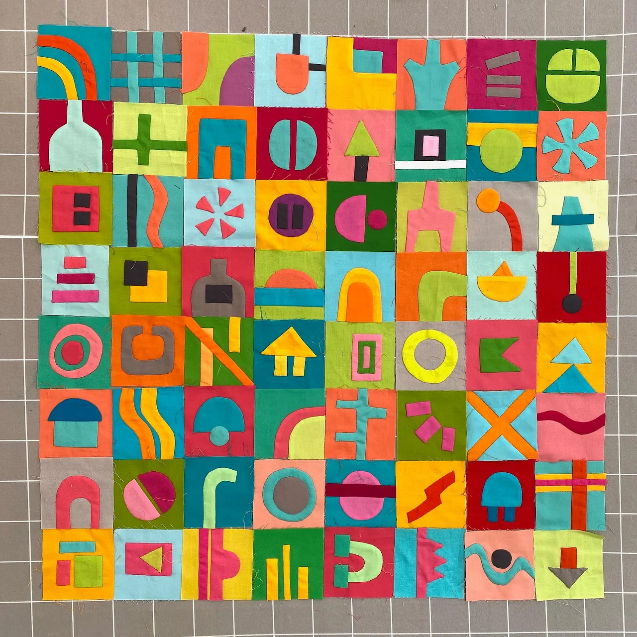 Colorful geometric quilt pattern with abstract shapes in bright squares