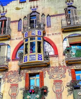Art Nouveau building with colorful mosaic decorations, balconies, and rainbow arch detail