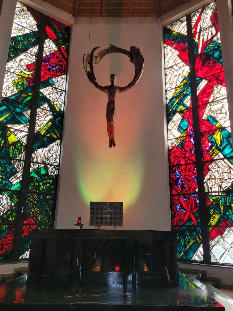 Church altar with crucifix sculpture and colorful stained glass windows