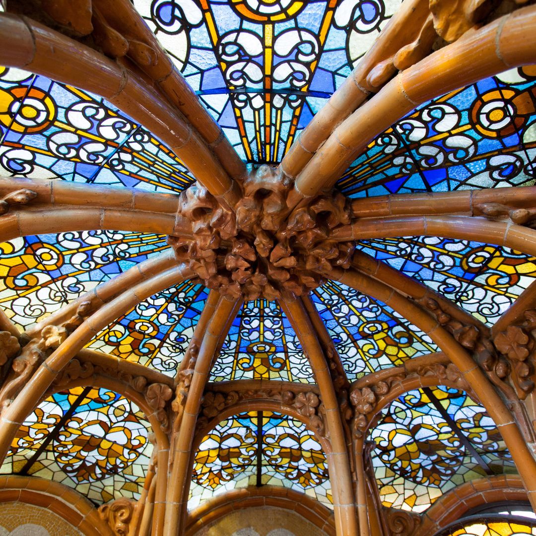 Ornate dome with radiating stone ribs and vibrant stained glass panels in blue, yellow, and orange