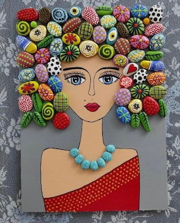 Portrait of woman with painted stones arranged as decorative hair against gray textured background