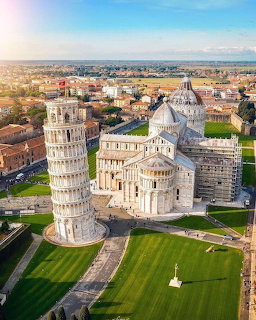 Aerial view of the Leaning Tower of Pisa andisa Cathedral in warm sunlight