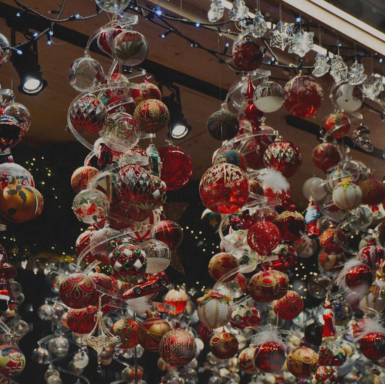 Clusters of red, white, and gold Christmas ornaments hanging at a market stall