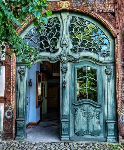Ornate weathered wooden doorway with arched brick frame and decorative carvings