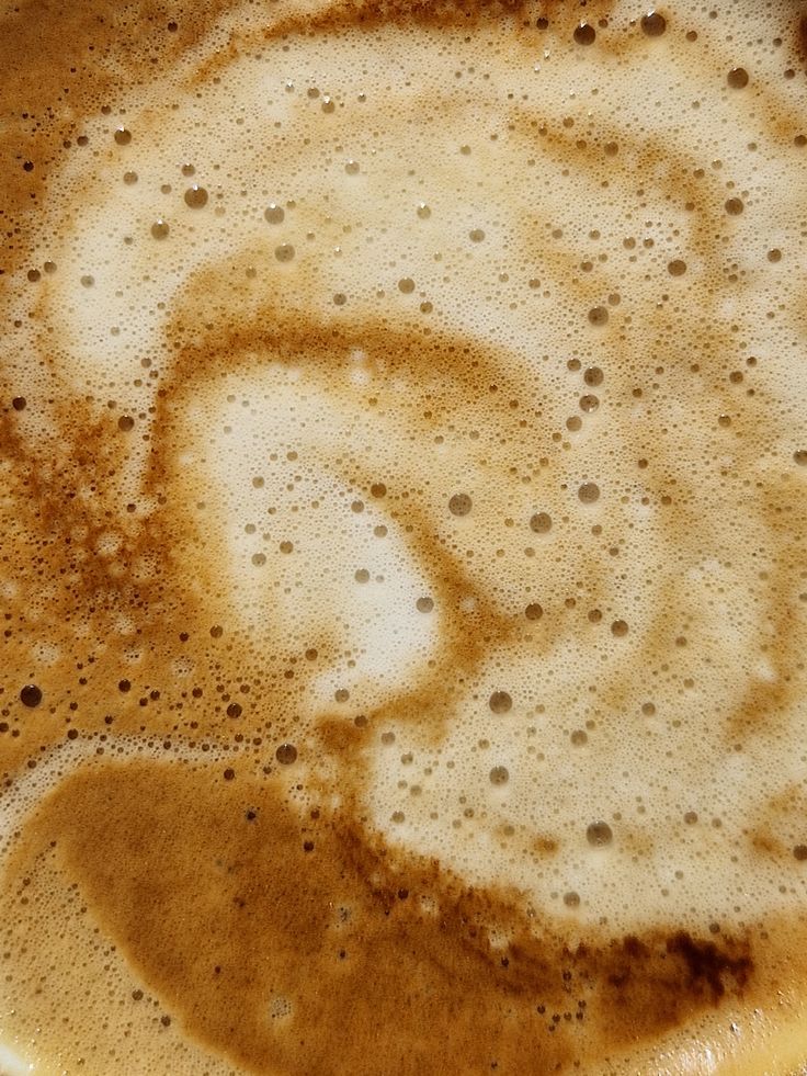 Close-up of coffee foam with swirling crema and small bubbles