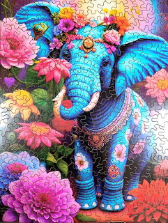 Colorful illustration of a decorated blue elephant surrounded by vibrant flowers