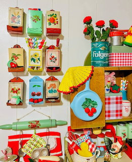 Colorful vintage kitchen collectibles with retro canisters, cherry motifs, rolling pins, and gingham decor