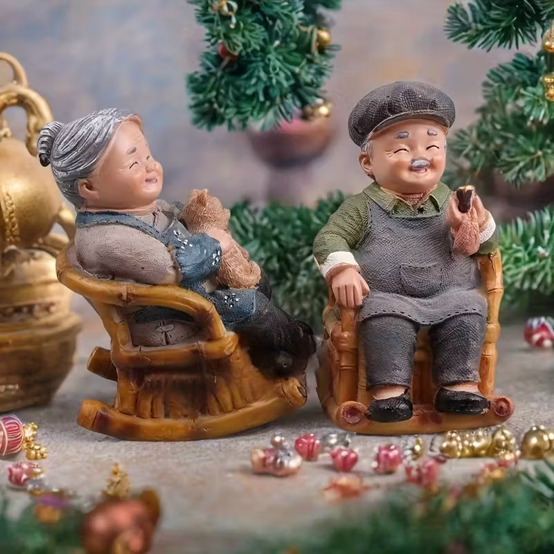 Elderly couple figurines in rocking chairs with Christmas decorations and miniature trees