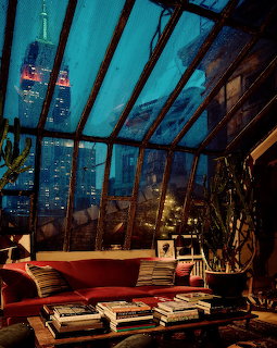 Modern room with glass ceiling showing Empire State Building and New York City skyline at dusk