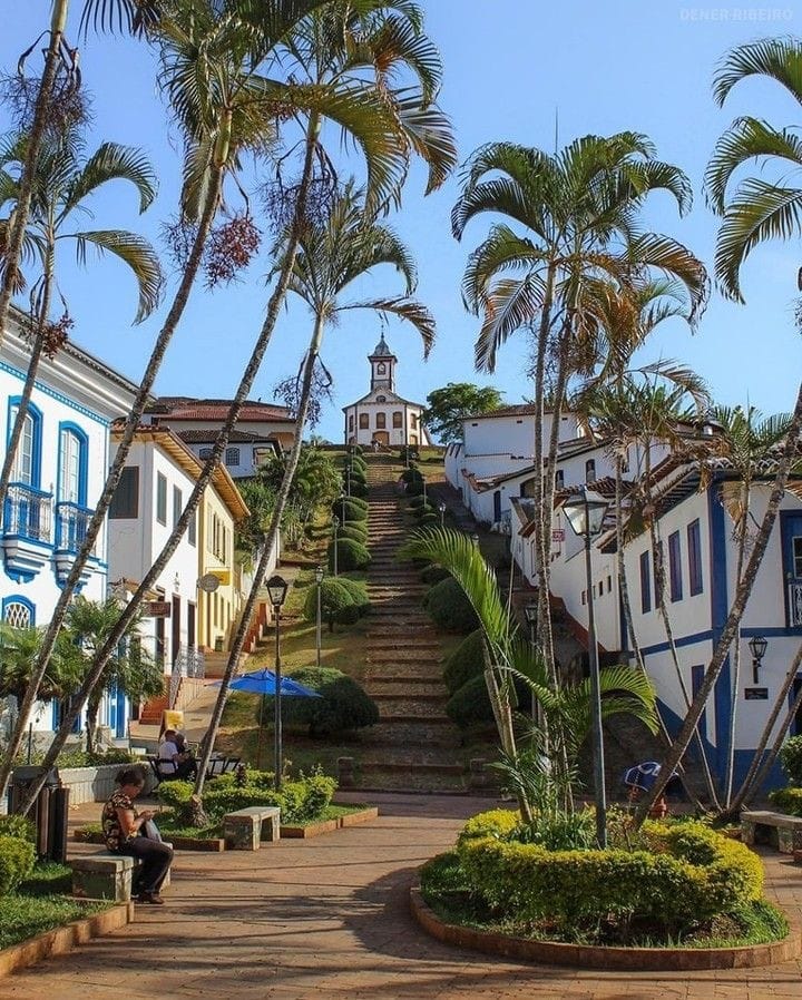 Wide stone stairway with palm trees leading to a colonial church in Serro, Minas Gerais, Brazil