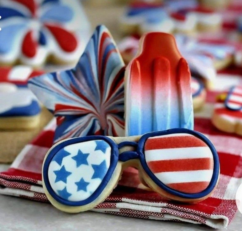Patriotic sunglasses with American flag design next to red white and blue popsicle and July 4th decorations