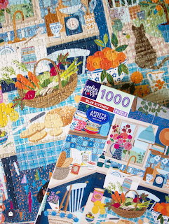 Overlapping jigsaw puzzles featuring lighthouses, beach scenes, flowers, and various colorful patterns
