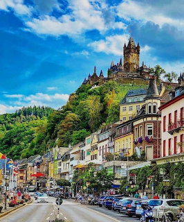Cochem Germany town street with colorful buildings and hiltop castle under blue sky