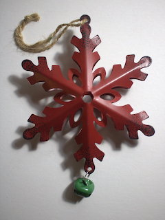 Red metal snowflake Christmas ornament with twine hanger and small green bell