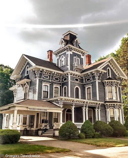 Ornate gray Second Empire Victorian house with mansard roof and tower in Winsted, Connecticut