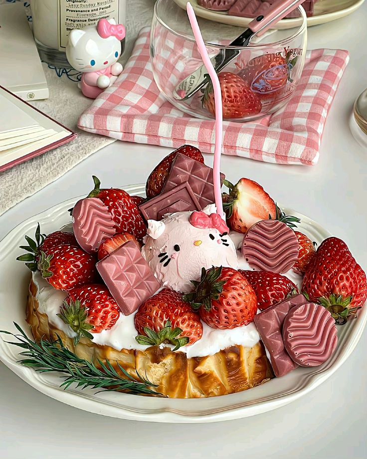Tiered dessert stand with strawberries, cake, macarons and Hello Kitty figurines on pink checkered cloth