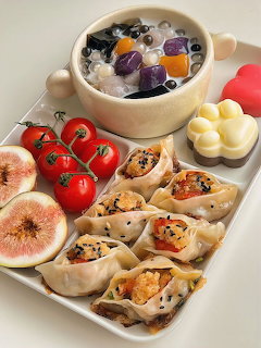 White platter with Korean dumplings, cherry tomatoes, figs, and a bowl of taro ball dessert soup