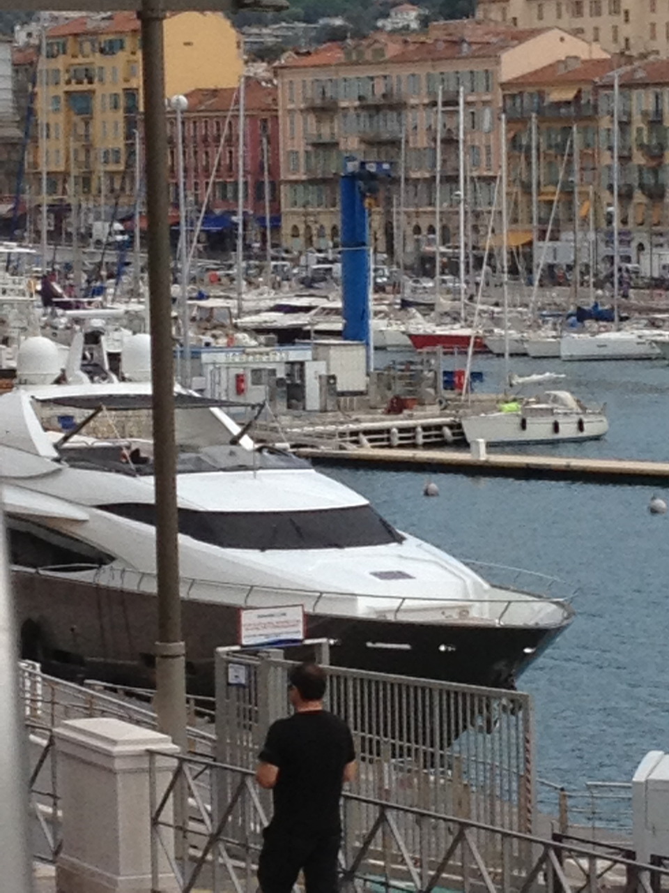 Luxury yachts moored at Nice harbor with colorful French Riviera buildings in the background