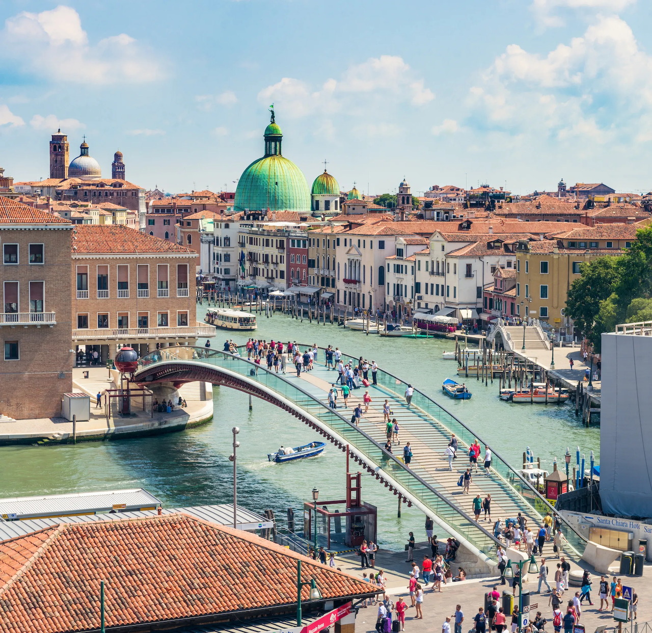 Constitution Bridge over the Grand Canal in Venice with boats, pedestrians, and historic buildings