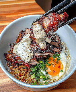 Chopsticks lifting glazed char siu pork over a rice bowl with egg and green onions