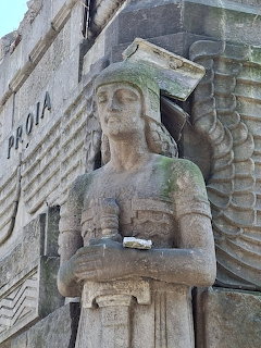 Stone sphinx statue with Egyptian headdress and wings on a building facade