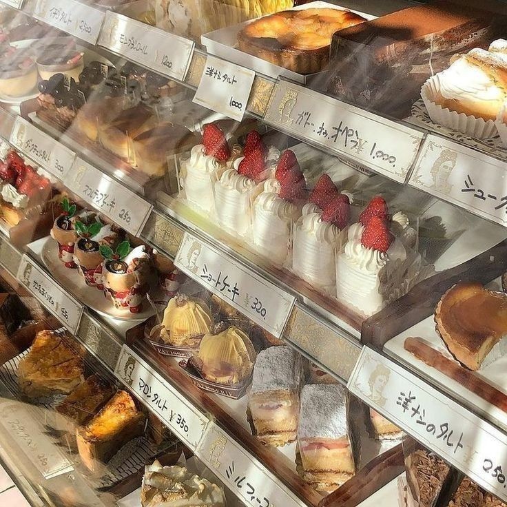 Japanese bakery display case with strawberry cakes and pastries behind glass with price labels
