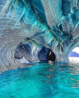 Blue and gray marble caves with turquoise water inside a natural rock cavern