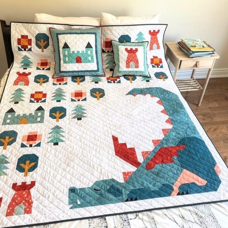 Quilted bedspread with teal dragon and castle pillow on white bed with floral pattern accents
