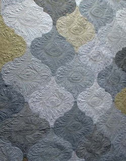 Quilted textile with embossed lattice pattern in gray and white tones
