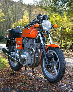 Orange Laverda Jota vintage motorcycle parked outdoors on a leafy path