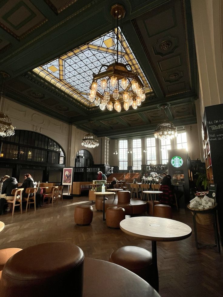 Ornate Starbucks cafe interior with stained glass ceiling, chandeliers, and wooden tables