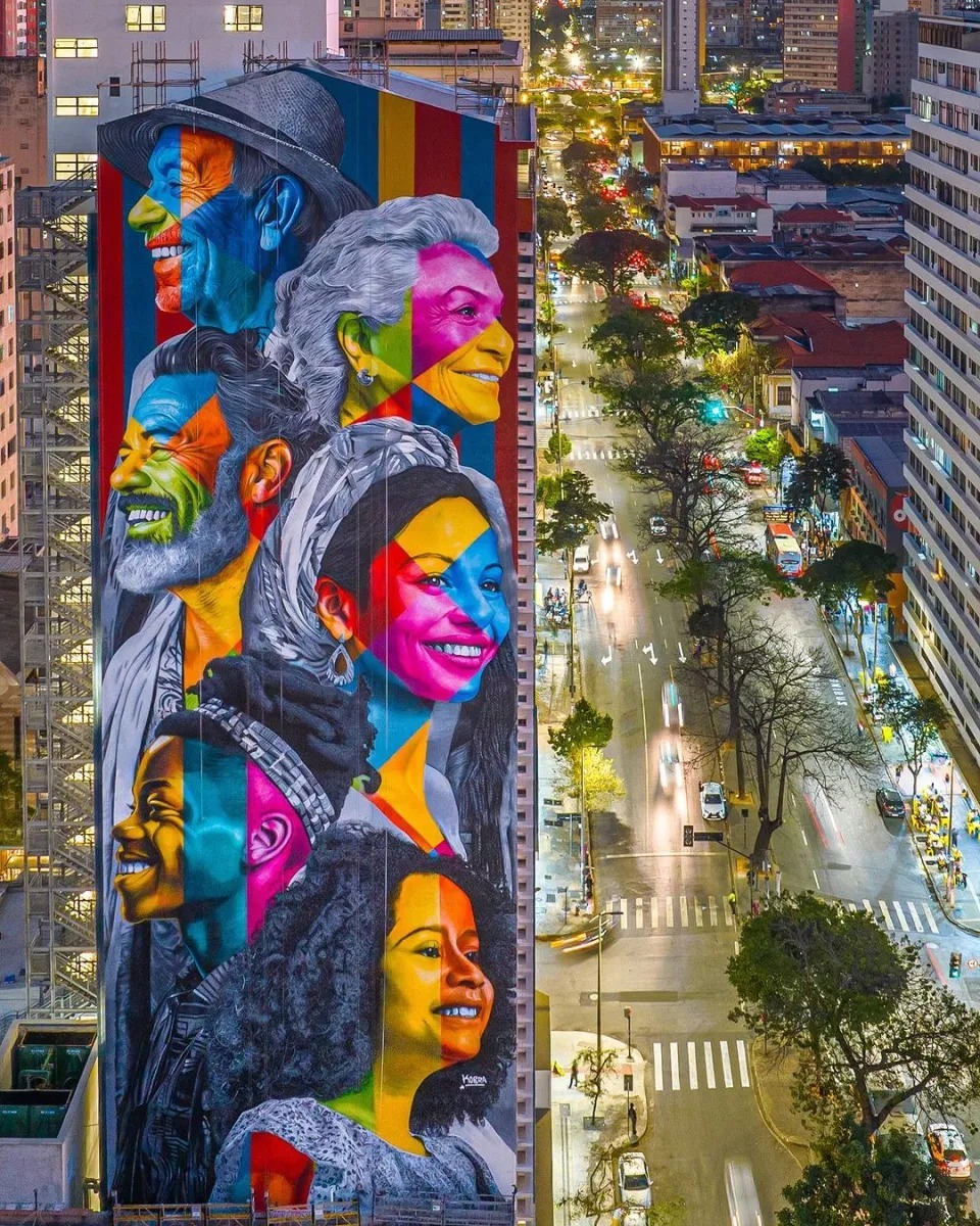 Colorful street art mural with multiple faces painted on building wall in urban Belo Horizonte