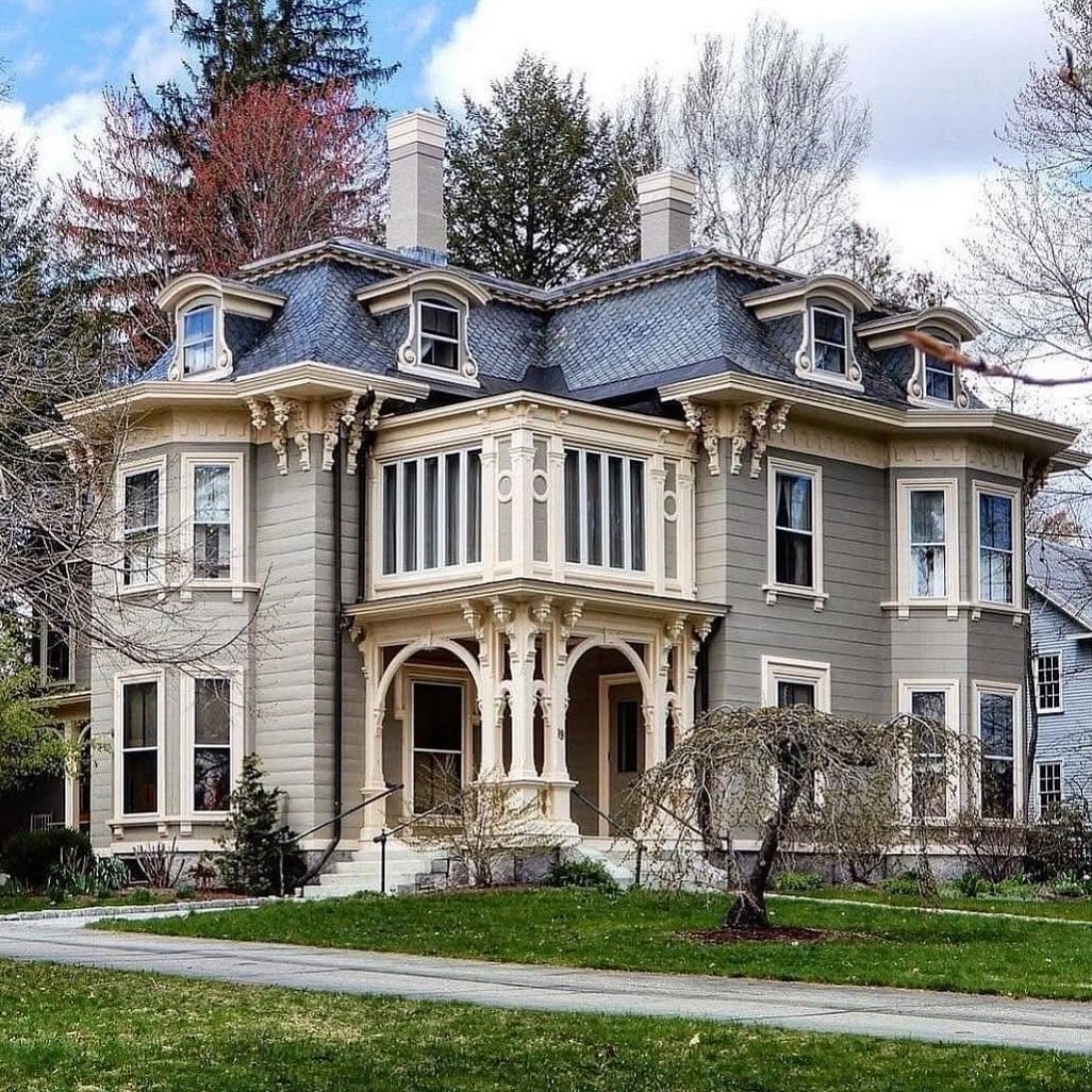 Historic Victorian house with ornate porch, dormer windows, and gray exterior