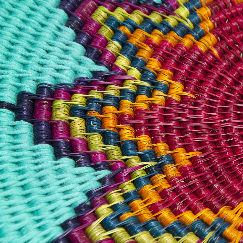 Close-up of colorful woven basket with turquoise, magenta, yellow and blue geometric pattern