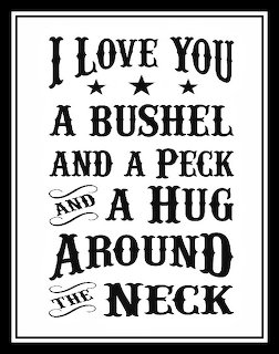 Black and white framed sign with vintage typography reading I love you a bushel and a peck and a hug around the neck