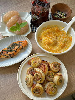 Tabletop spread with salmon, porridge, pastries, fruit, and a drink