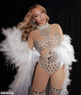 Beyoncé in a rhinestone bodysuit and white feather boa at the Renaissance World Tour