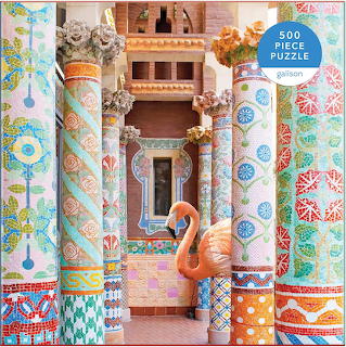 Colorful mosaic hall with decorated columns, archways, and pink flamingo sculpture in ornate Spanish interior