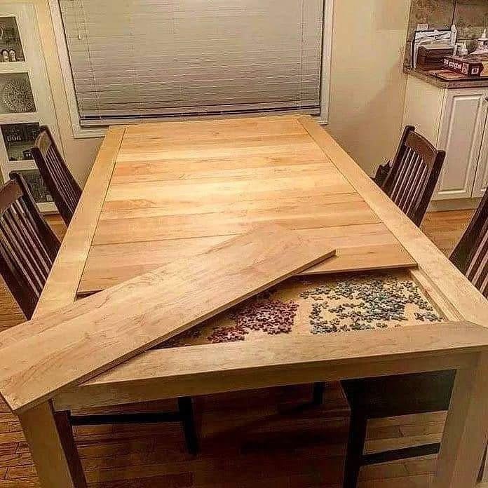 Wooden dining table with a partially open top revealing hidden storage beneath