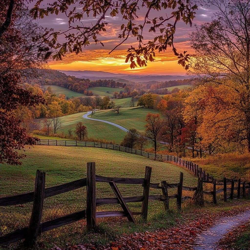 Autumn landscape with wooden fence, fall trees, rolling hills and golden sunset sky