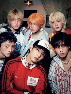 Six young men in colorful styled hair and fashionable clothing posing together for group photo