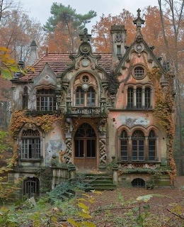 Weathered Gothic house surrounded by autumn trees and overgrown plants