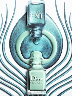Two pale blue cosmetic bottles in a vertical symmetric arrangement with circular and wavy metallic elements