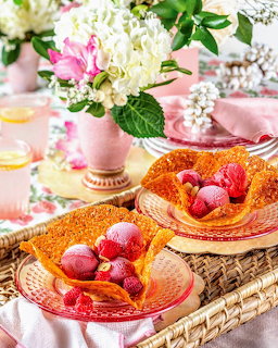 Easter table decorated with pink eggs, white and pink flowers, and amber glass plates