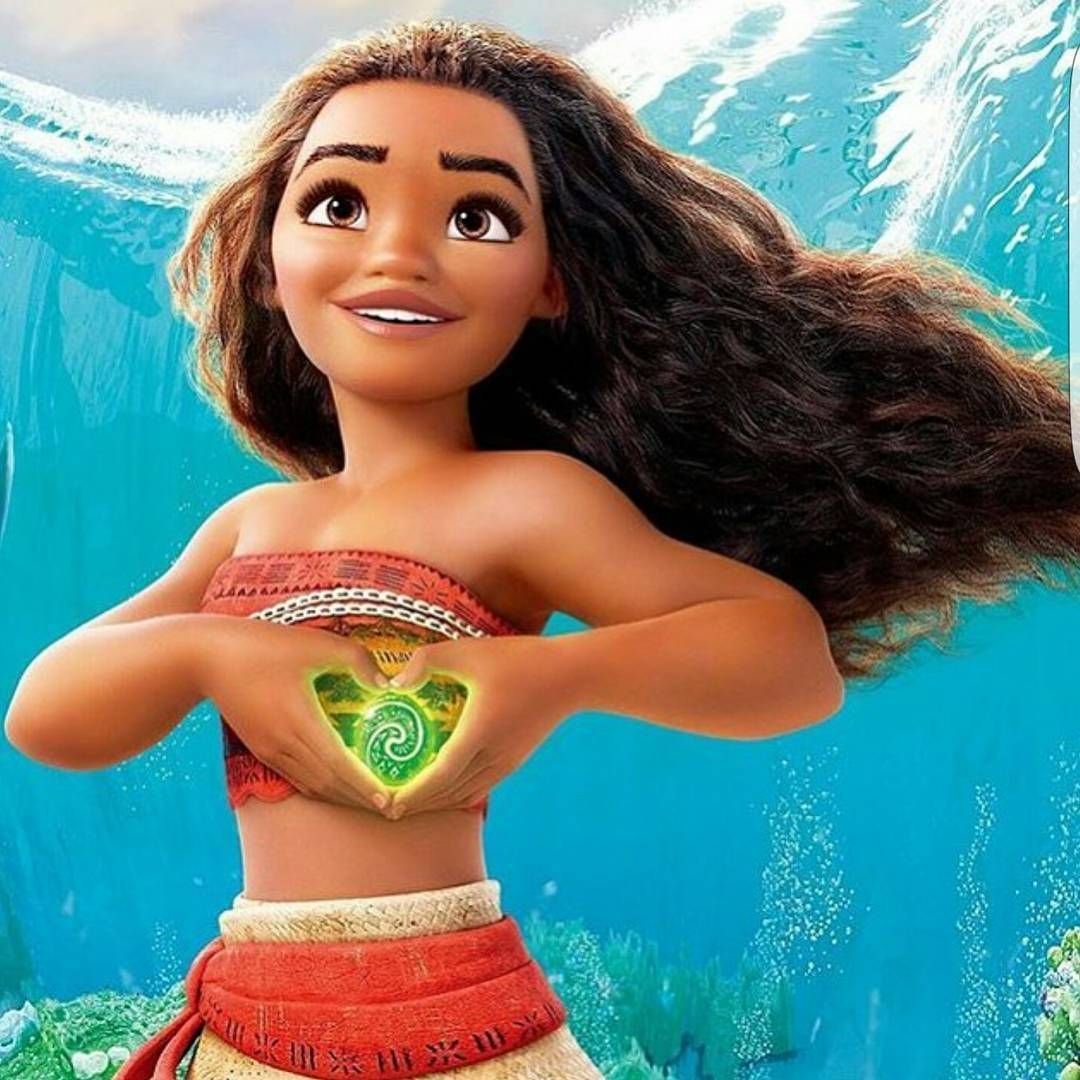 Moana underwater holding a glowing green heart stone with flowing hair