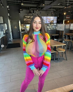 Woman wearing rainbow striped crop top and pink pants in restaurant interior