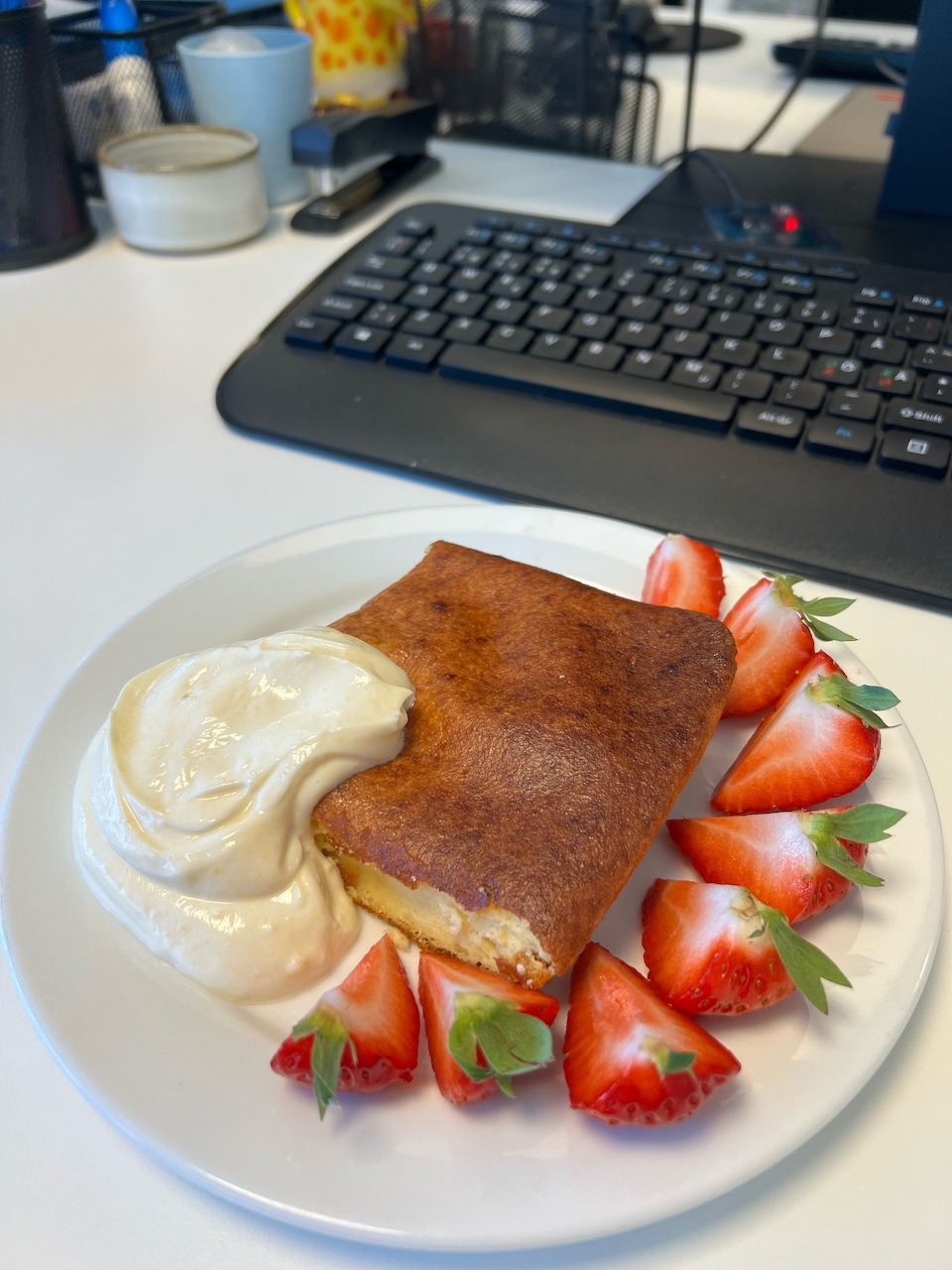 Chocolate crepe with cream cheese filling, strawberries and whipped cream on white plate