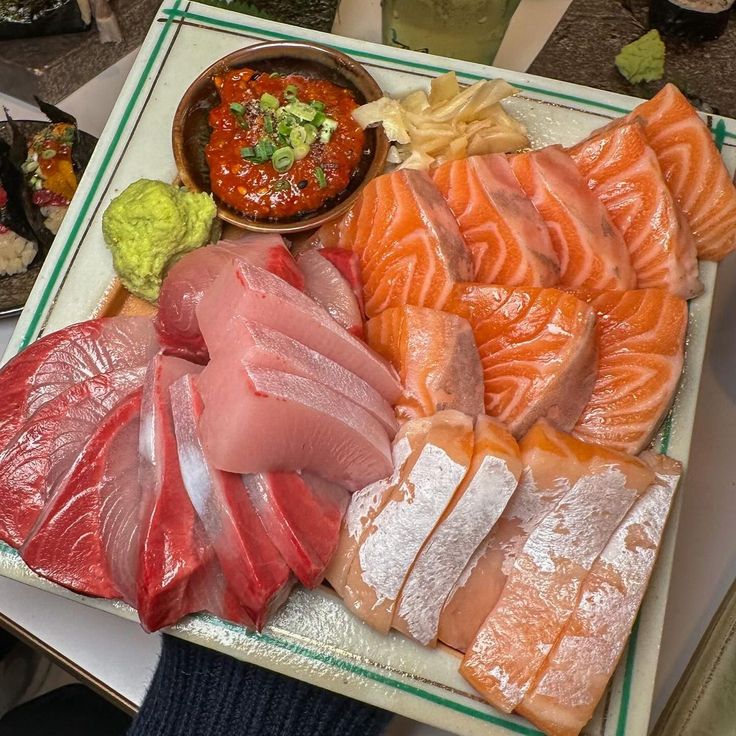 Platter of salmon and tuna sashimi with sauce, wasabi, and pickled ginger
