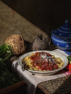 Bowl of pasta with tomato sauce and grated cheese in a rustic kitchen still life